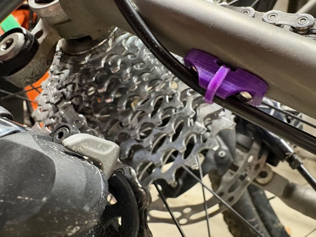 A replacement cable guide that accommodates full length housing on the chain stay of a Lynskey R300